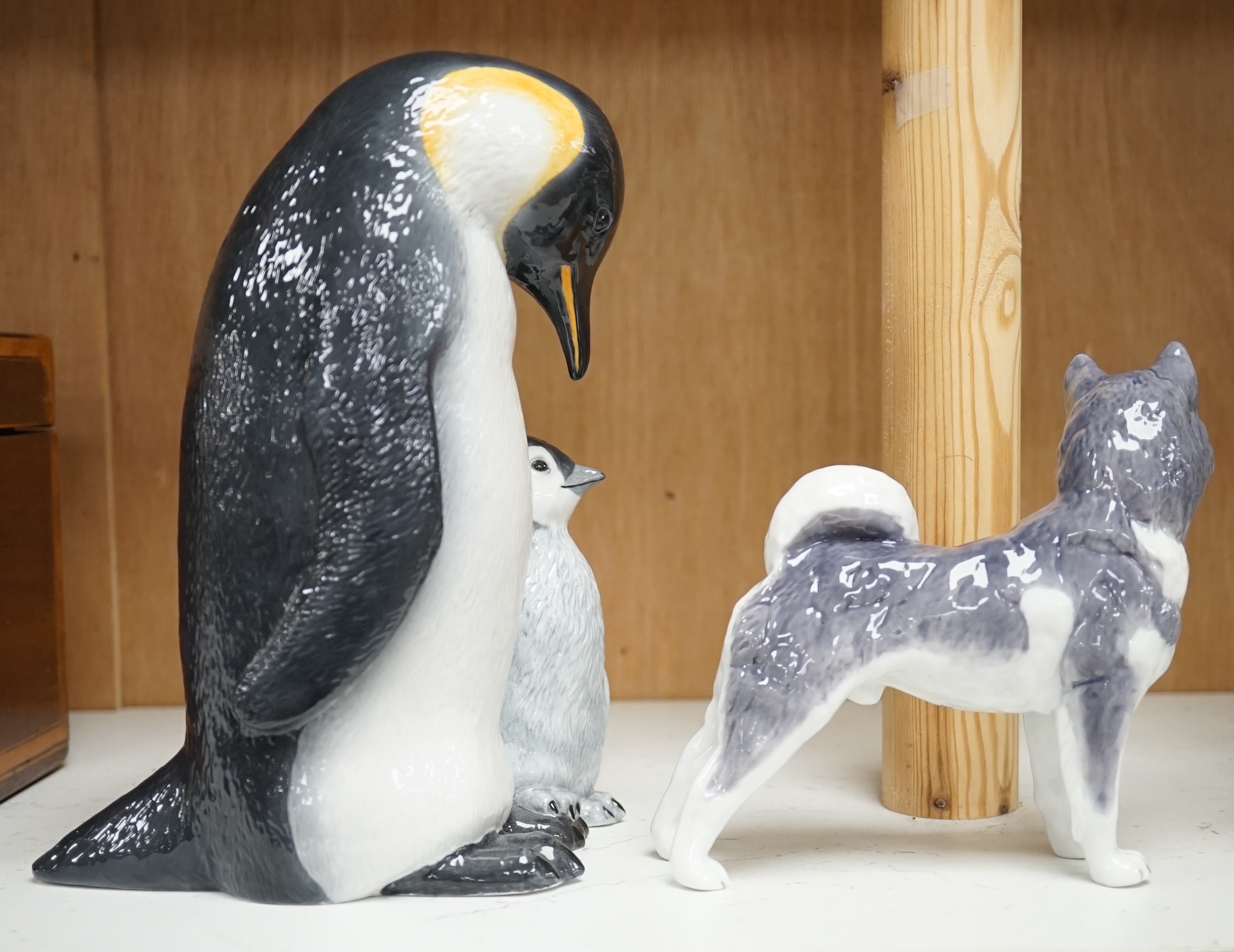 A Royal Copenhagen penguin group and a similar husky figure, 088 and 038, tallest 22cm. Condition - good